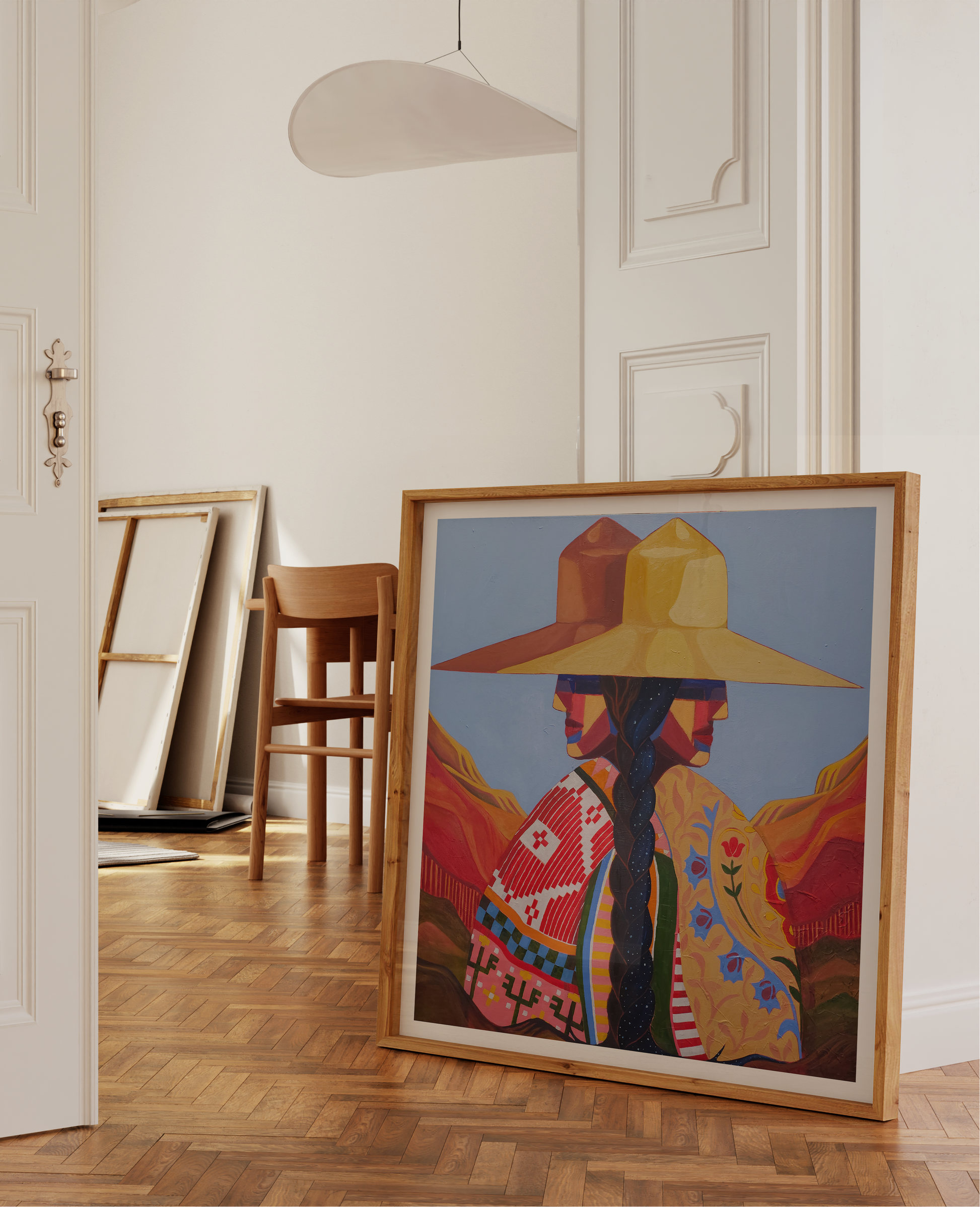 Framed artwork of a person wearing a colorful hat in a room with wooden floor and white walls.